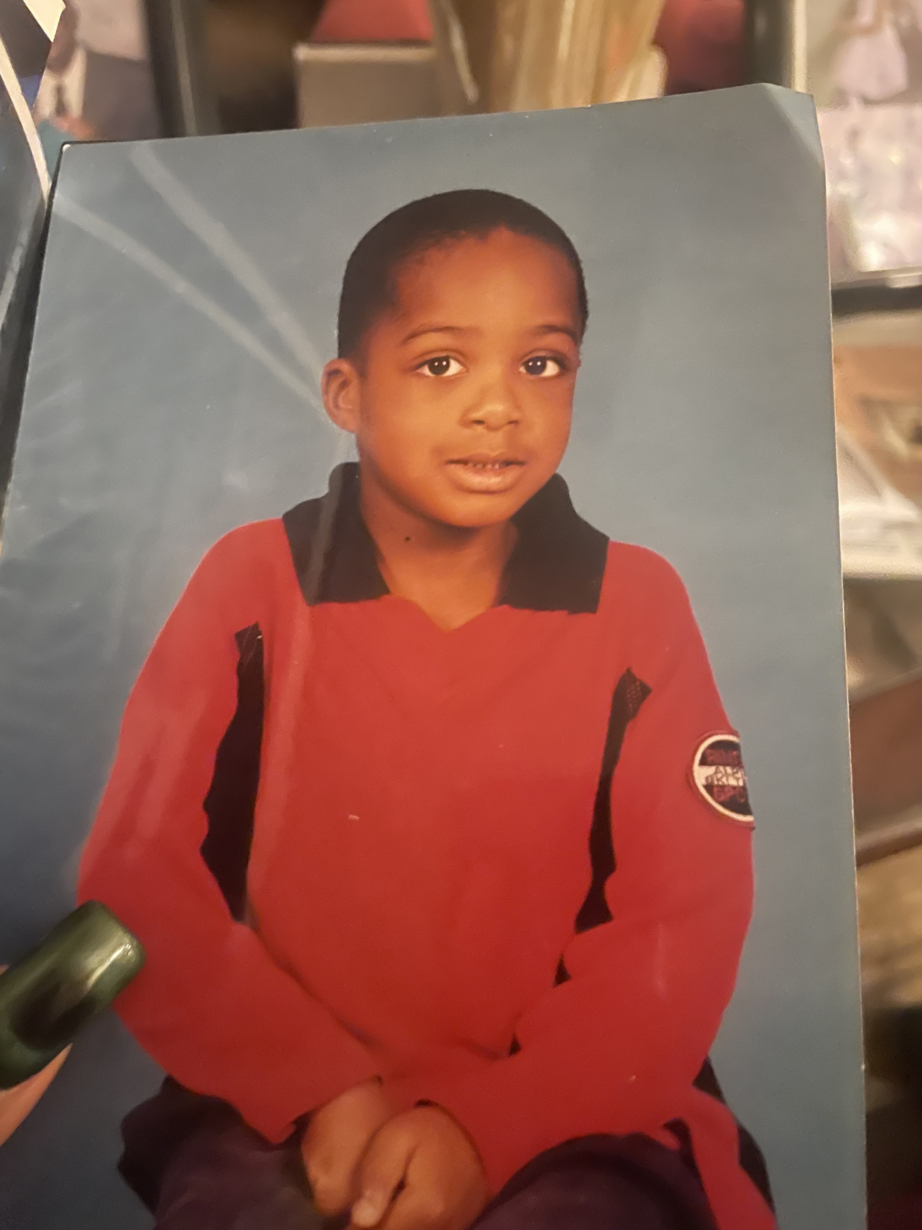 OpenAI example input: a printed portrait of a child in a red shirt